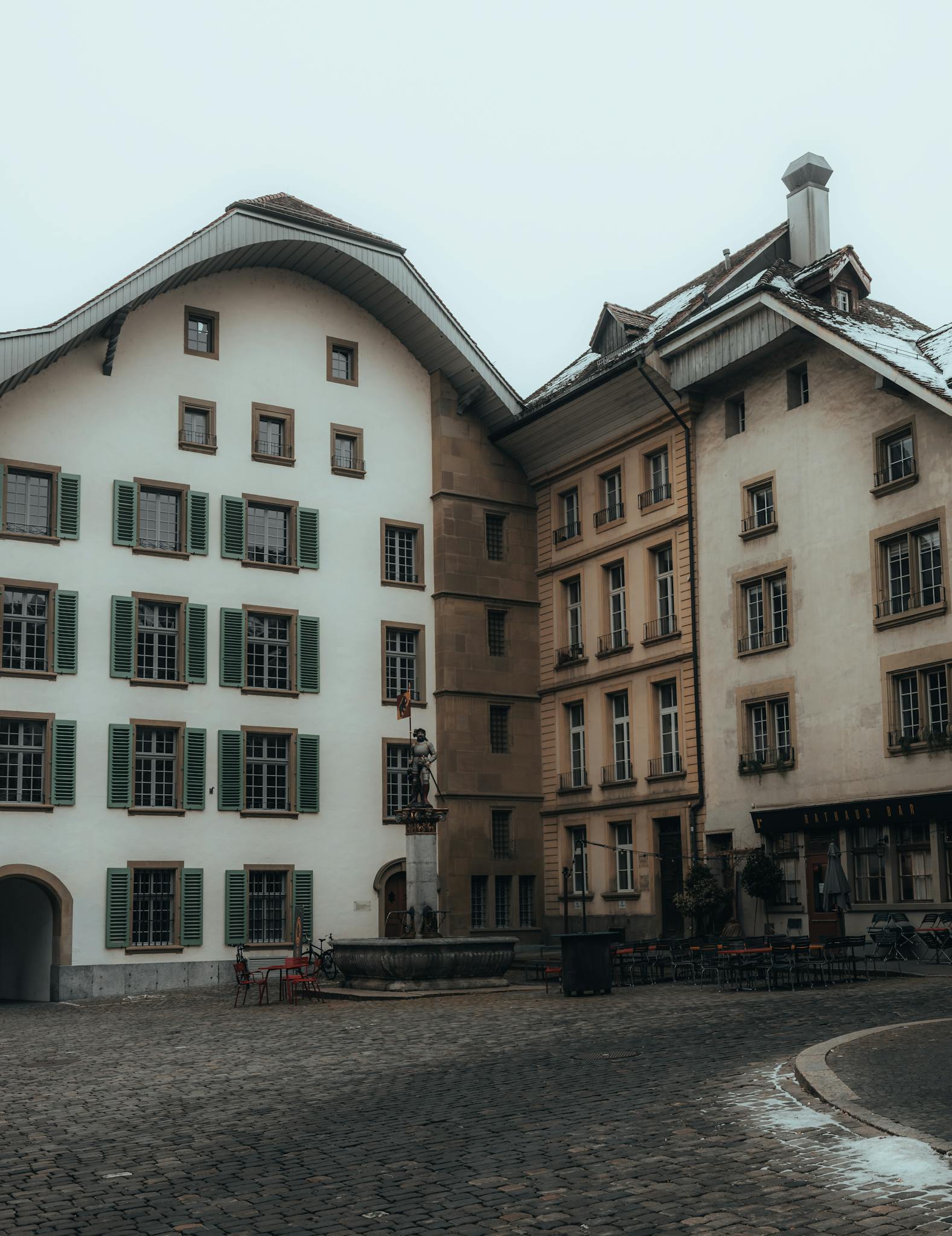 Elegant European architecture with cobblestone square and historic buildings.